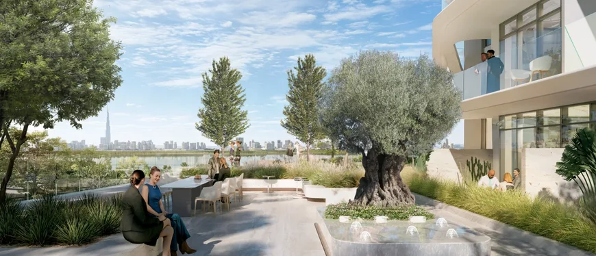 Landscaped podium terrace at Sanctuary Hive with mature olive trees, water features and the Downtown Dubai skyline beyond